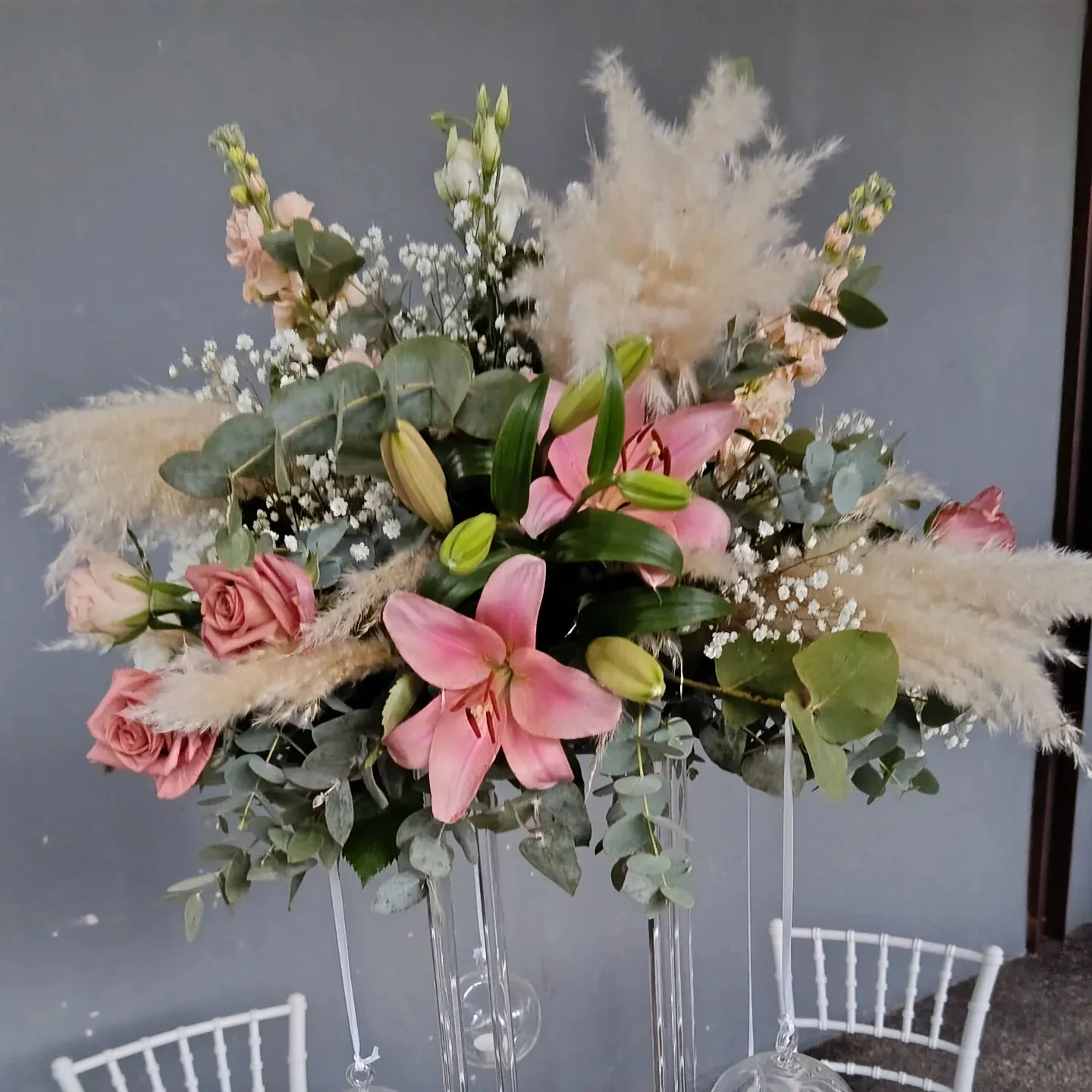 Centrotavola da matrimonio con pampas, lilium rosa, rose ed eucalipto