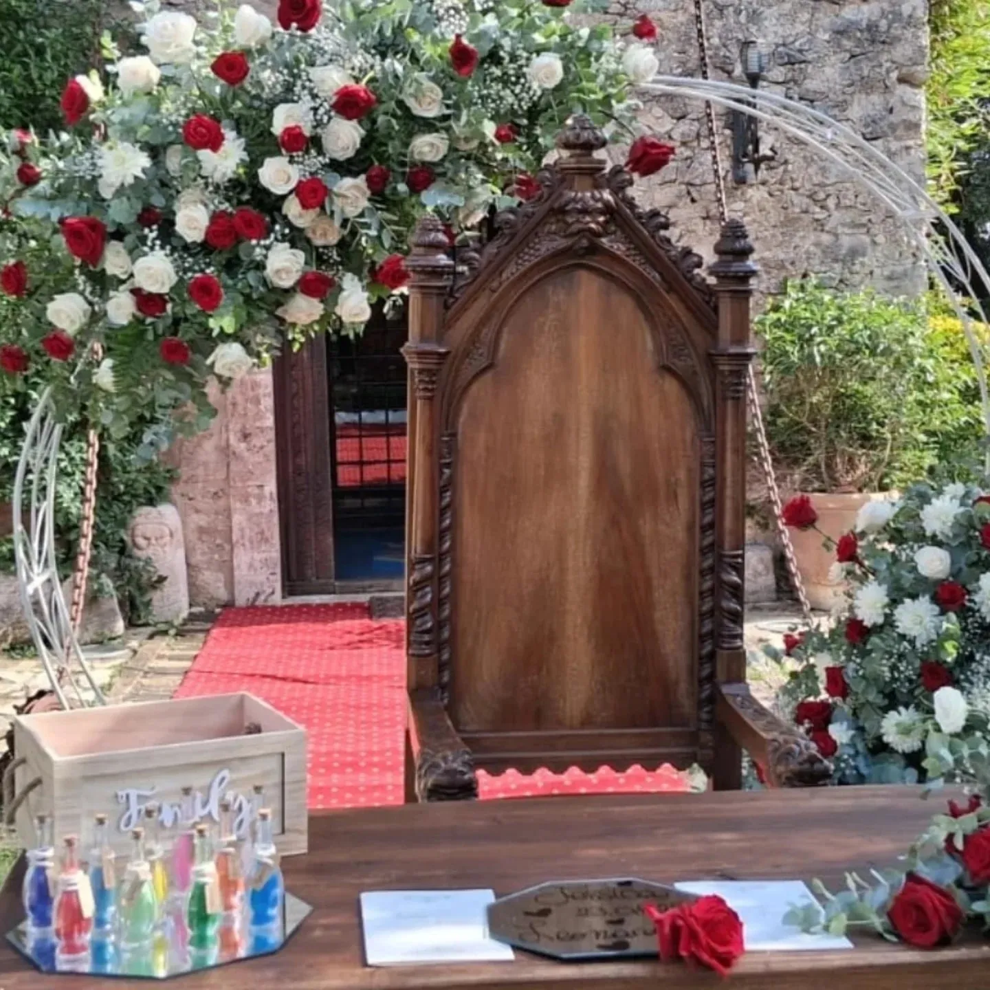 Arco di rose rosse e bianche per una cerimonia all'aperto in una villa storica
